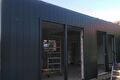 Aanbouw met donkere gevelbekleding en grote glazen pui