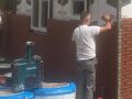 Metselaar van Tombouw aan het werk aan een bakstenen gevel